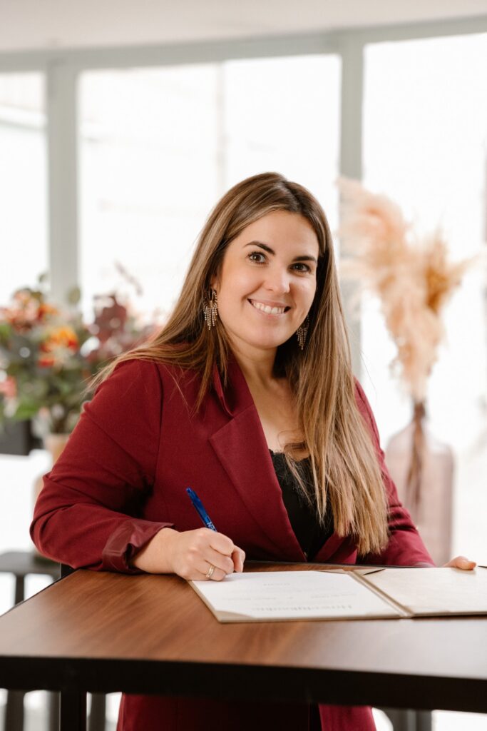 Vrouw in rood jasje aan bureau tijdens kennismaking voor branding- en coachingsdiensten
