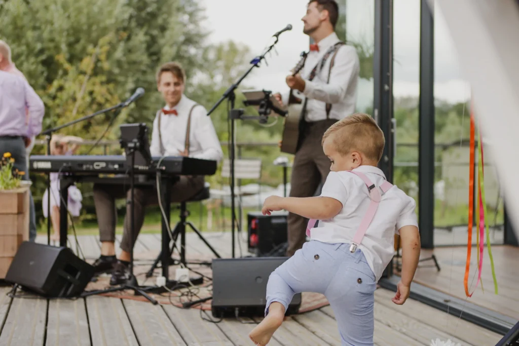 Trouwceremonie buiten met muzikanten, zanger en bruidegom in pak op podium